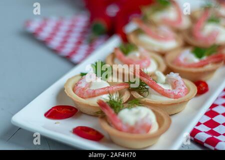 Törtchen mit Frischkäse und Garnelen. Mit Zweige Dill und Petersilie dekoriert. Fisch und Meeresfrüchte. Urlaub Gericht. Auf einem hellen Hintergrund. Kopieren Sie Platz. Stockfoto