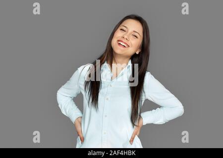 Freestyle. Junge Frau, die isoliert auf Grau posing Lachen heiter Stockfoto