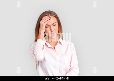 Freestyle. Junge Frau, die isoliert auf weißem in Kopfschmerzen Kopf unglücklich berühren. Stockfoto