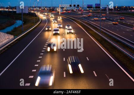 Abends Verkehr verläßt leichte Wanderwege auf der Autobahn A9 mit unscharfen Autos in der Nähe von Amsterdam, Schiphol nach Haarlem. Stockfoto