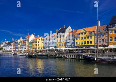 Kleine Segelboote auf dem Nyhavn Kanal vor hellen Gebäude in Kopenhagen, Dänemark Stockfoto