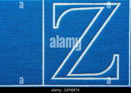 Der Buchstabe Z im Lehrbuch Nahaufnahme. Makro Textur des blauen Tuch Buch Cover. Hintergrund Stockfoto