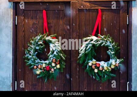 Advent Weihnachten Kranz auf hölzernen Tür Dekoration. Schneit. Stockfoto