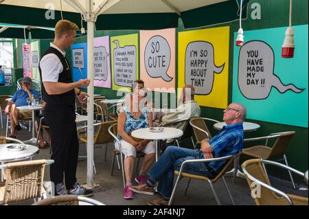 Ein paar Gespräche mit einem Kellner in einem Café in Kopenhagen, Dänemark. Stockfoto