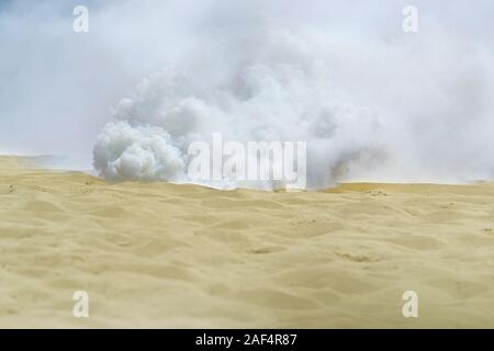 Explosion und Wolken von Rauch auf dem Sand Stockfoto