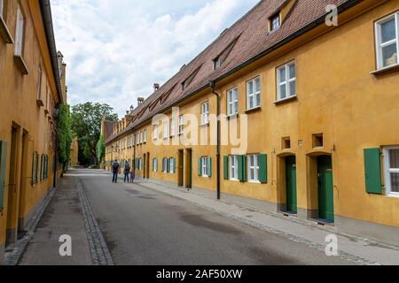 Blick auf eine typische Straße in der Fuggerei, einen Ummauerten Enklave innerhalb der Stadt Augsburg, Bayern, Deutschland. Stockfoto