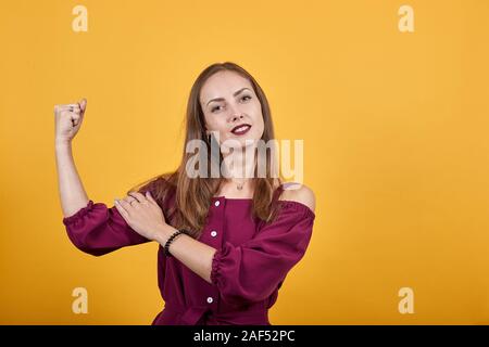 Frau mit langem Haar vor isolierten orange Wand tun starke Geste Stockfoto