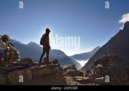 Silhouette der westlichen Frau, die auf einem Berg in Nepal mit klaren blauen Himmel Stockfoto