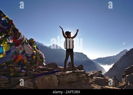 Silhouette der westlichen Frau, die auf einem Berg in Nepal mit klaren blauen Himmel Stockfoto