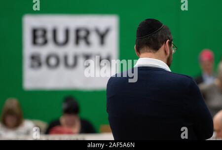 Bury, Großbritannien. 13. Dezember 2019. Ein Mann mit einem Skull Cap steht in der Halle der Bury Süden wahlkreis als Stimmen gezählt. Ivan Lewis, MP der Wahlkreis, bis November 2019, trat von der Labour Party auf seine Unzufriedenheit mit der Partei auf den Antisemitismus. Quelle: Russell Hart/Alamy leben Nachrichten Stockfoto