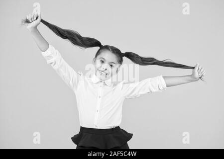 Schülerin Schüler lange Haare cute Pferdeschwänze Frisur. Pädagogisches Programm. Adorable Schulmädchen. Homeschooling oder besuchen regelmäßig die Schule. Die Effizienz des Studiums. Emotionaler Ausdruck Schulmädchen. Stockfoto