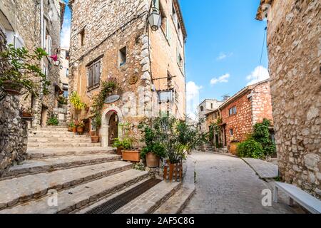 Eine malerische zurück Straße mit Geschäften und Wohnungen im mittelalterlichen Dorf Tourrettes sur Loup in der Alpes Maritimes im Süden von Frankreich. Stockfoto