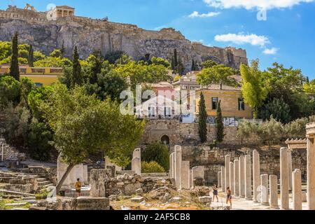 Touristen besuchen Sie die Ruinen der alten römischen Agora unter der Aussicht auf den Parthenon und die Akropolis Hügel im Stadtteil Plaka in Athen, Griechenland. Stockfoto