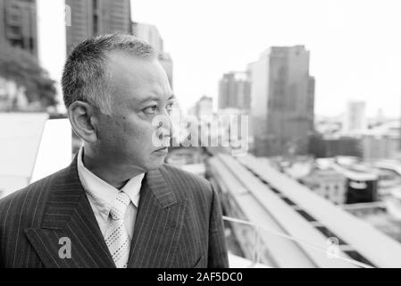 Reifen asiatische Geschäftsmann gegen den Blick auf die Stadt Stockfoto