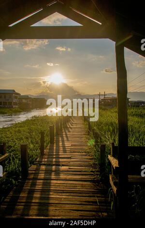 Sonnenuntergang auf der hölzernen Brücke an maing Thauk Dorf in Inle See in Myanmar (Birma) Stockfoto