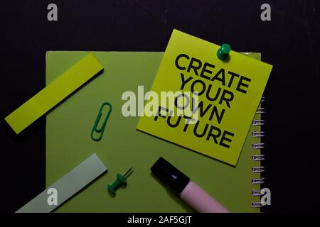 Erstellen Sie Ihre eigene Zukunft auf Haftnotizen schreiben. Draufsicht auf schwarzem Hintergrund isoliert. Stockfoto