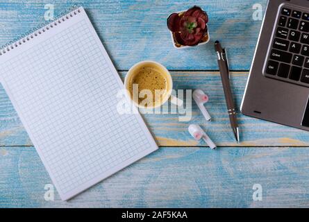 Modernen Arbeitsplatz mit Notepad, Kopfhörer, Brille, Stift und Kaffee Tasse auf Laptop Tastatur office Stockfoto