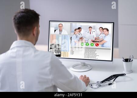 Junge männliche Arzt Video-chats auf Laptop in der Klinik Stockfoto