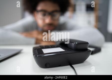 Junge Unternehmer, die auf einen Anruf warten auf Festnetz Stockfoto