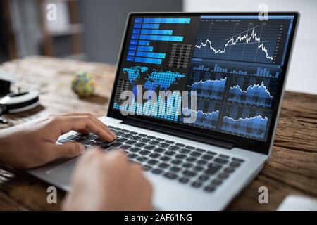 In der Nähe von einem Geschäftsmann Hand Analyse von Graphen auf Laptop Stockfoto