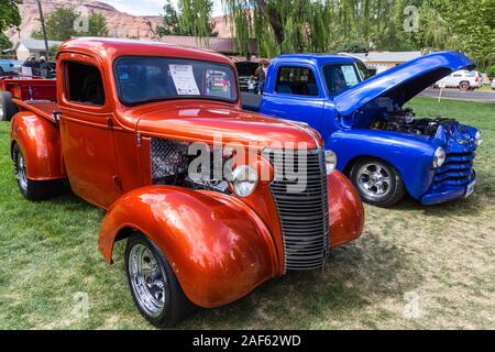 Ein restauriertes und modifizierte 1938 Chevy Pickup Truck in der Moabiter April Aktion Auto Show in Moab, Utah. Daneben ist ein blauer 1951 Chevy 3100 Pickup Truck. Stockfoto