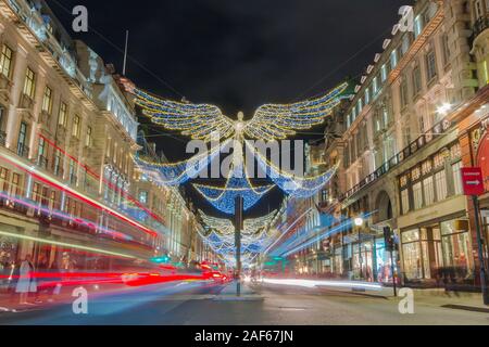 Weihnachten Engel Dekorationen in der Regent Street in London hängt. Lange Belichtung erstellen leichte Spuren von Autos und Busse. Stockfoto