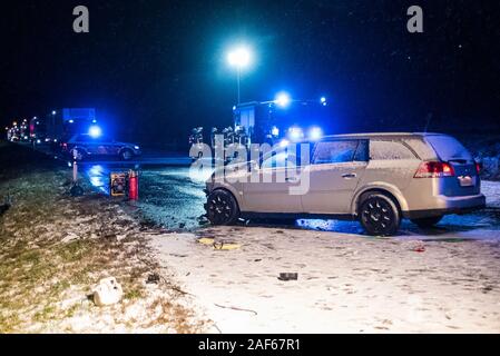 Albstadt, Deutschland. 13 Dez, 2019. Eines der beiden Fahrzeuge in den Unfall verwickelt ist über die B 463 Autobahn in der Nähe von Albstadt, im Hintergrund sind die Einsatzfahrzeuge der Feuerwehr und die Feuerwehr. Nach Angaben der Polizei hatte eine 24 Jahre alte Fahrer wurde getoetet, als sie die Kontrolle über ihr Auto auf einem schneebedeckten Fahrbahn verloren. Sie stieß mit einem 40 Jahre alten Auto. Dieses wurde leicht verletzt. Credit: Jannik Nölke/dpa - ACHTUNG: Das nummernschild pixelated wurde aus Gründen der Persönlichkeitsrechte/dpa/Alamy leben Nachrichten Stockfoto