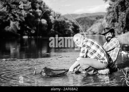 Die illegale Jagd Kaviar. Auszüge Eier vom Stör gefangen. Trap für Fische. Männer sitzen am Flußufer mit Angelausrüstung. Die wilderei Kriminalität und Lizenz. Wilderer angeln. Schwarzmarkt Kaviar. Stockfoto