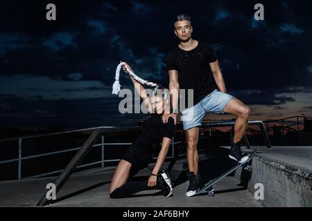 Stilvolle Paare in den Skate Park am Abend Stockfoto