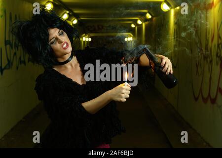 Freaky Frau in dunklen Tunnel mit Flasche Bombe in den Händen Stockfoto