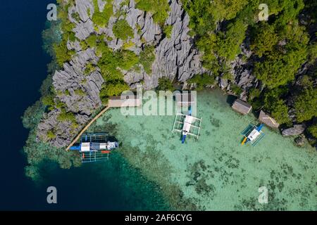 Luftaufnahme von Auslegerbooten, die in einer Lagune, Coron, Palawa, Philippinen festgemacht sind Stockfoto