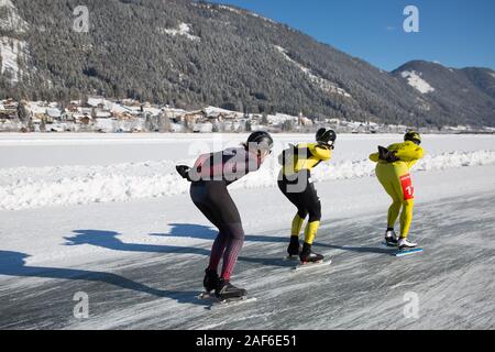 Schlittschuhlaufen auf dem See, in einem schönen Winterlandschaft. Meisterschaft Marathon Ice Speed-Skating auf Natureis, Weissensee, Österreich Stockfoto