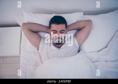Close-up oben über Hohe Betrachtungswinkel Porträt seiner er schöne attraktive Brünette Kerl liegen auf weißen Bett ruht friedlich schlafen nachts spät Stockfoto