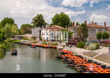 Orange touristische Sportboote auf der Sevre Niortaise Fluss in der malerischen Stadt Coulon, Alpes-de-Haute-Provence (79) im Marais Poitevin, Frankreich Stockfoto