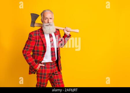 Foto von cool Opa weißen Bart Holding Big ax Hände spielen Serienmörder Rolle bei Halloween wear Plaid rot Kostüm Outfit isolierte helle gelbe Stockfoto