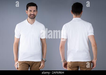 Portrait eines glücklichen jungen Mann, der auf grauem Hintergrund Stockfoto