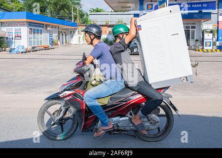 Zwei Männer sitzen auf dem Motorrad mit großem Kühlschrank oder