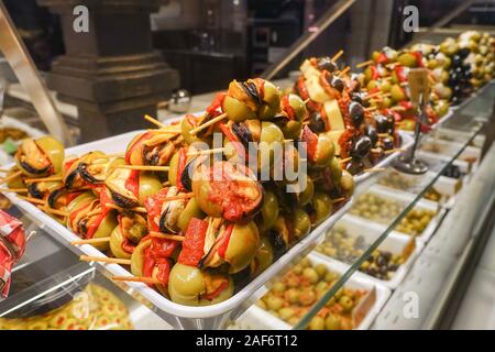 Gefüllte grüne Oliven auf Holzstäbchen zum Verkauf an Mercado Markt San Miguel in Madrid, Spanien Stockfoto