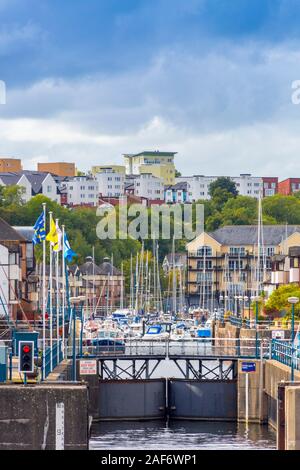 Der Eingang zum Kais Penarth Marina, Cardiff Bay mit attraktiven neuen Gehäuse Architektur am Kai und Hügel jenseits, Glamorgan, Wales, Großbritannien Stockfoto