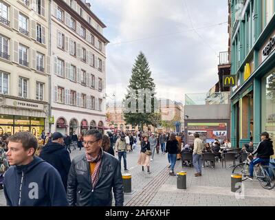 Paris, Frankreich, 02.November 2019: Einheimische, Touristen und Menschen zu Fuß auf der Main Street in Straßburg mit hohen Tannenbaum im Hintergrund während der jährlichen Weihnachtsmarkt Stockfoto