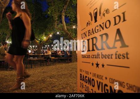 Besucher genießen Sie einen Abend in der jährlichen Bagno Vignoni Sommer Toskanisches Handwerk Bier Festival - "Un Bagno di Birra' Toskana Italien EU - Juli 2019 Stockfoto