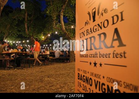 Besucher genießen Sie einen Abend in der jährlichen Bagno Vignoni Sommer Toskanisches Handwerk Bier Festival - "Un Bagno di Birra' Toskana Italien EU - Juli 2019 Stockfoto