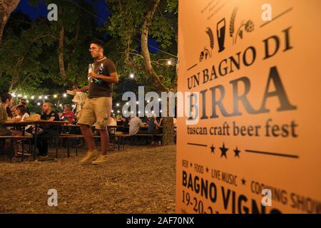 Besucher genießen Sie einen Abend in der jährlichen Bagno Vignoni Sommer Toskanisches Handwerk Bier Festival - "Un Bagno di Birra' Toskana Italien EU - Juli 2019 Stockfoto