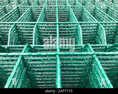 Regen fällt auf grün gefärbten Metallgitter. Stockfoto