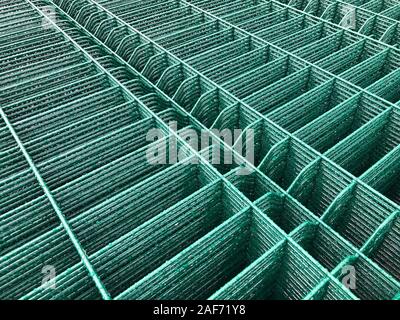 Regen fällt auf grün gefärbten Metallgitter. Stockfoto