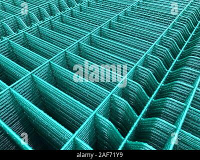 Regen fällt auf grün gefärbten Metallgitter. Stockfoto