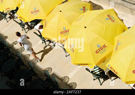 Gelbe Sonnenschirme und Kellnerin auf der Terrasse in Valletta, Malta Stockfoto