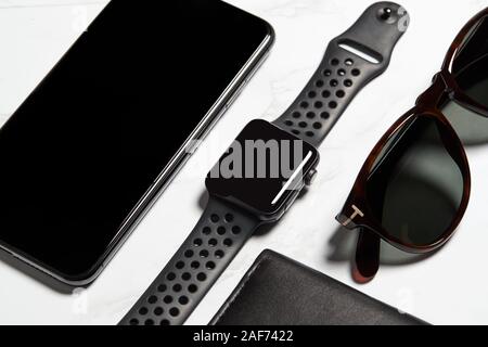 Flach Schuß von Techno Artikel für moderne Arbeiter mit Smartwatch Handy und Sonnenbrille Stockfoto