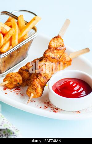 Gebackenes Huhn Kebabs In einem Teller mit Kartoffeln Pommes und Ketchup. Close Up. Stockfoto