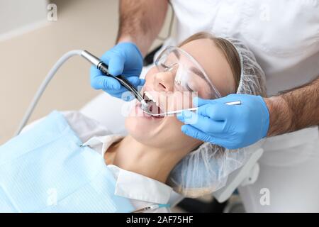 Zahnarzt bohren Zähne der jungen womans Verlegung im Stuhl. Selektive konzentrieren. Stockfoto